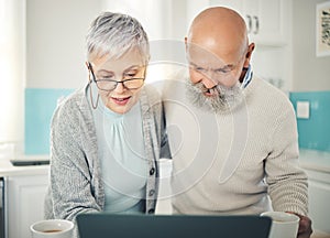 Senior couple, laptop and video call in home kitchen, internet browsing or social media in house. Computer, retirement