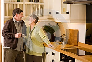 Senior couple laughing in designer kitchen