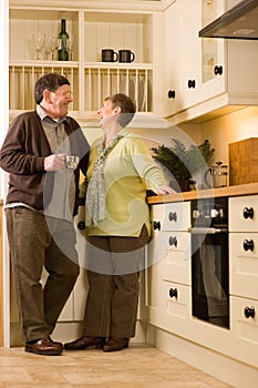 Senior couple laughing together in kitchen