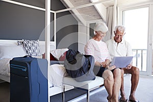 Senior Couple Look At Laptop As They Check In To Vacation Rental