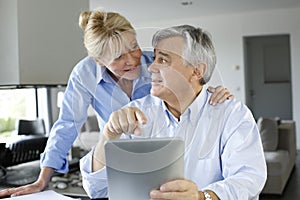 Senior couple looking at bank account on tablet