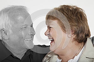 Senior couple looking at each other against white background