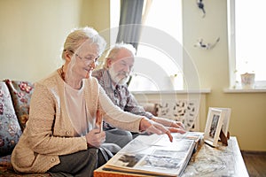 Senior couple looking at family photo album