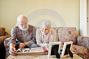 Senior couple looking at family photo album