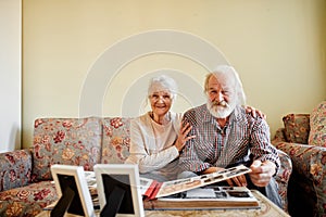 Senior couple looking at family photo album