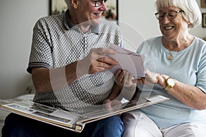 Senior couple looking at family photo album