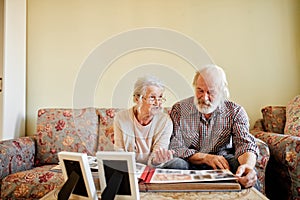 Senior couple looking at family photo album