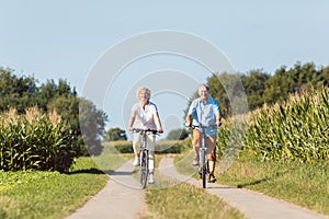 Senior couple looking forward with confidence while riding bicyc