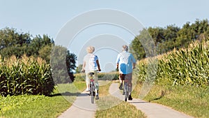 Senior couple looking forward with confidence while riding bicycles