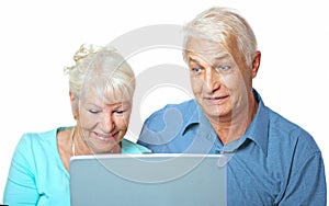 Senior couple looking happy at the laptop