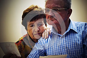 Senior couple looking at old photographs.