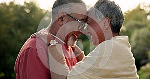 Senior couple, love and forehead touch in garden for hug, care and quality time together. Happy face of elderly man