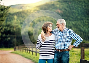 A senior couple in love looking at each other outdoors in nature. Copy space.