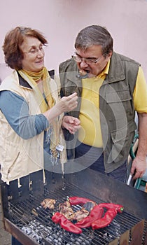 Senior couple making barbecue