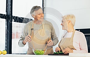 Senior Couple Making Dinner Cooking Smiling Each Other In Kitchen