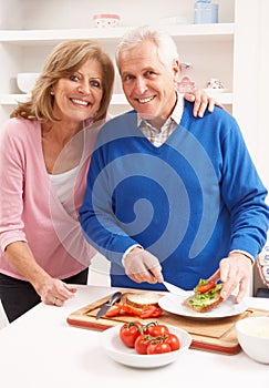 Senior Couple Making Sandwich In Kitchen