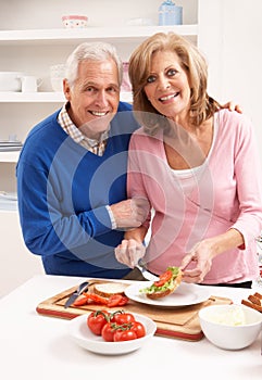 Senior Couple Making Sandwich In Kitchen