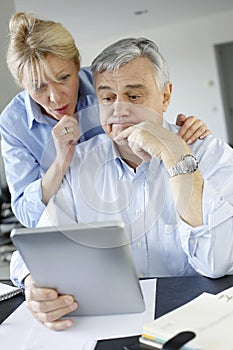 Senior couple making tax declaration with tablet