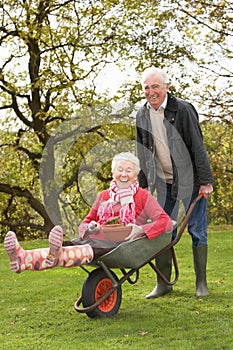 Senior Couple Man Giving Woman Ride In Wheelbarrow