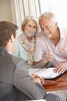 Senior Couple Meeting With Financial Advisor At Home