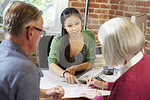 Senior Couple Meeting With Financial Advisor In Office