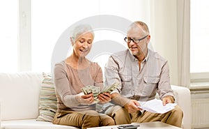 Senior couple with money and calculator at home