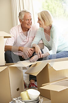 Senior Couple Moving Home And Packing Boxes