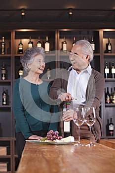 Senior Couple Opening Wine Bottle