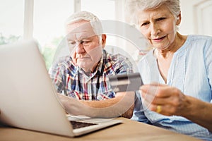 Senior couple paying bills online