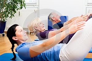 Senior couple in physiotherapy doing sit-ups