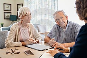 Senior couple planning their investments with financial advisor photo