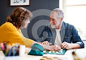 Senior couple playing board games in community center club.