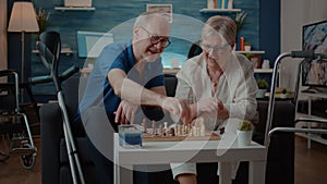 Senior couple playing chess board game with pieces