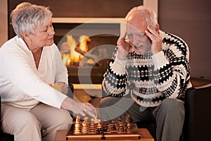 Senior couple playing chess at home