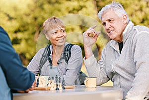 Senior couple playing chess in nature after a wellness, fresh air and health walk in a garden. Happy, smile and elderly