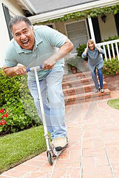 Senior couple playing with children's scooter