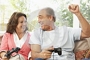 Senior Couple Playing Computer Game At Home