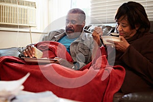 Senior Couple With Poor Diet Keeping Warm Under Blanket