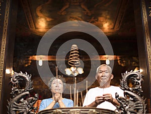 Senior couple praying buddha with incense stick