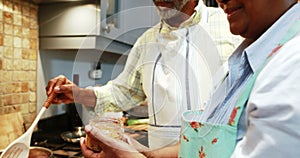 Senior couple preparing food in kitchen