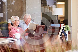 Senior Couple Putting Letter Into Keepsake Box