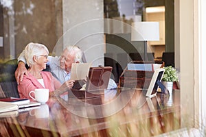 Senior Couple Putting Letter Into Keepsake Box