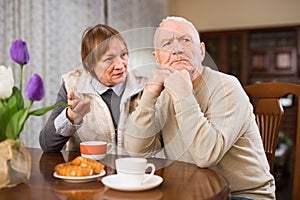 Senior couple after quarrel in living room