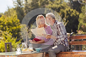 Senior couple reading in the backyard