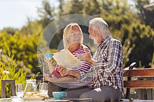 Senior couple reading and drinking coffee outdoor