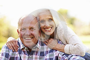 Senior Couple Relaxing In Autumn Landscape