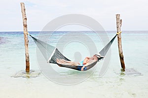 Senior Couple Relaxing In Beach Hammock