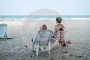 Senior couple relaxing on the beach, watching the sea