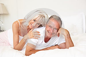 Senior Couple Relaxing On Bed photo
