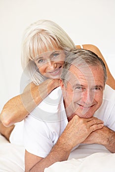 Senior Couple Relaxing On Bed